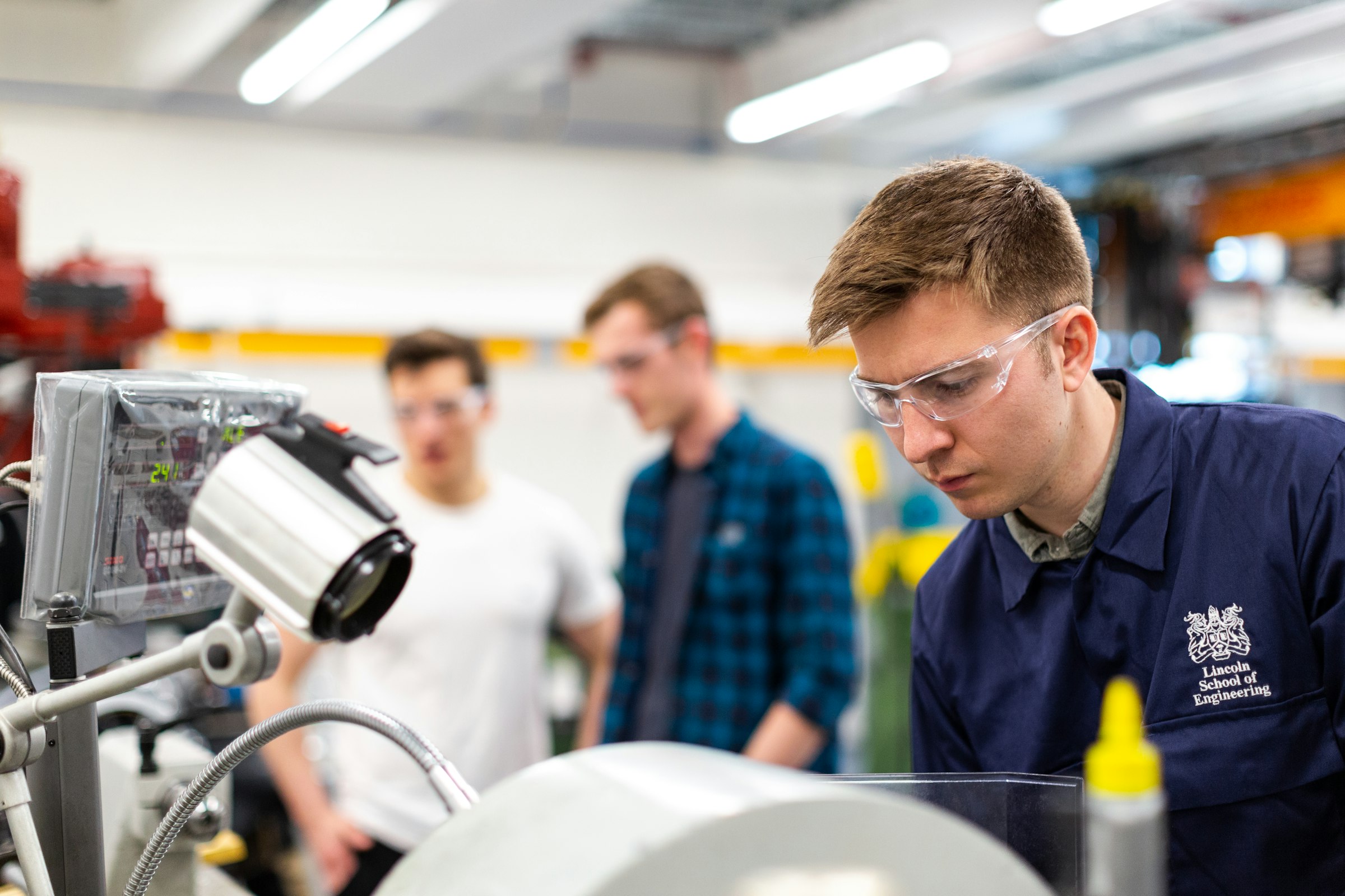 Quality control inspector examining Bluetooth speaker electronics on modern production line