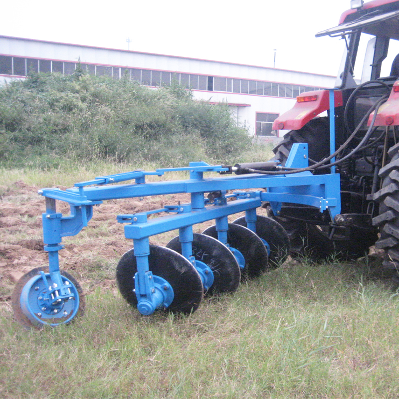 1LYS reversible disc plough attached to a tractor in a field