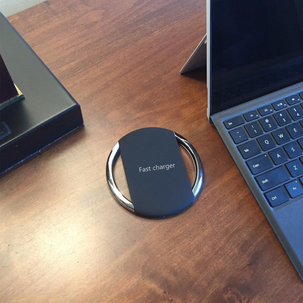 Zinc alloy wireless charger next to a laptop