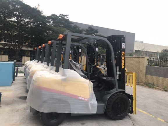 Forklift with paper roll attachment in industrial setting