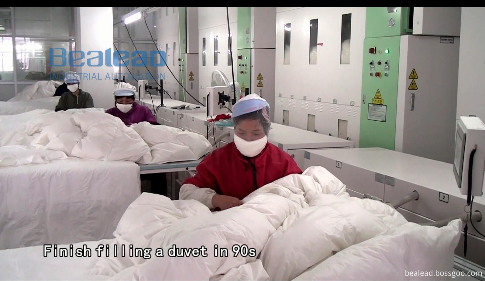 Workers operating the duvet filling station