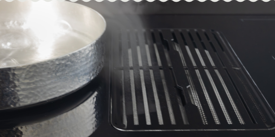 Sleek black induction cooktop with integrated downdraft