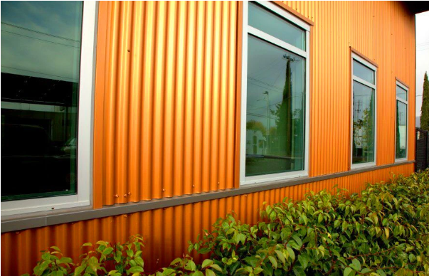 Building facade using finished corrugated metal sheets
