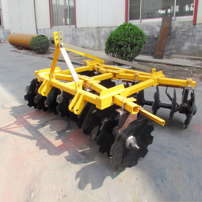 Mounted disc harrow with red steel frame and black notched discs