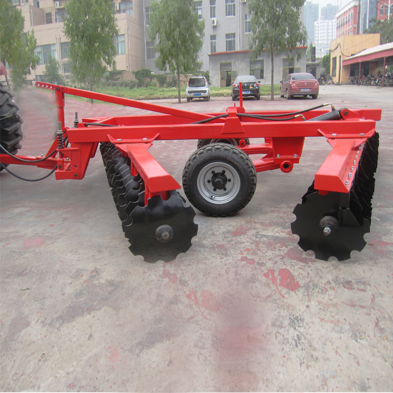 Close up of disc harrow assembly with trailing wheel