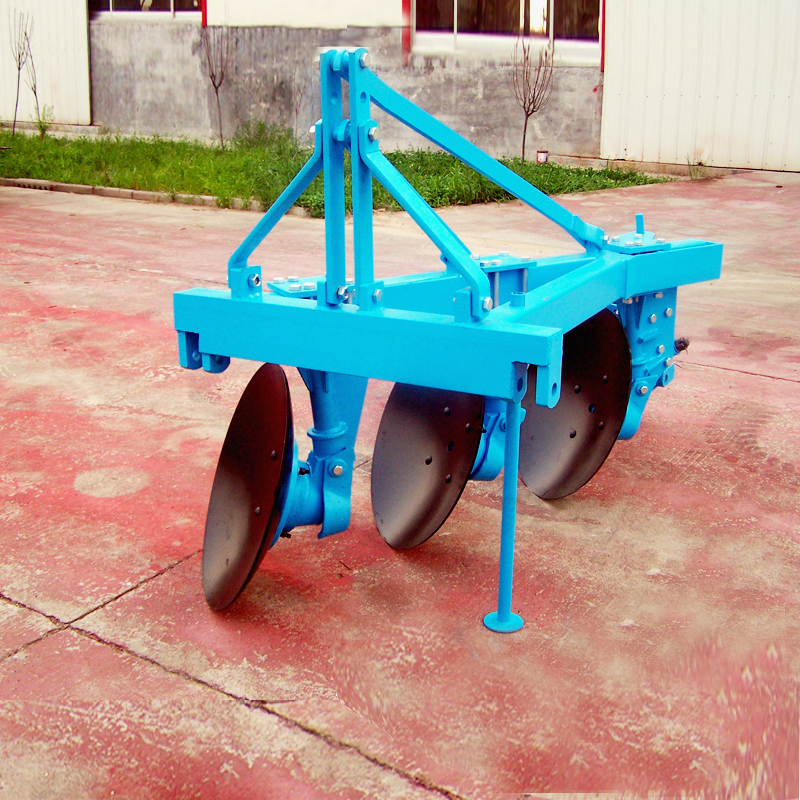 Tractor-mounted disc plough in operation
