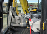 Interior view of the excavator cabin showing operator seat and dashboard controls
