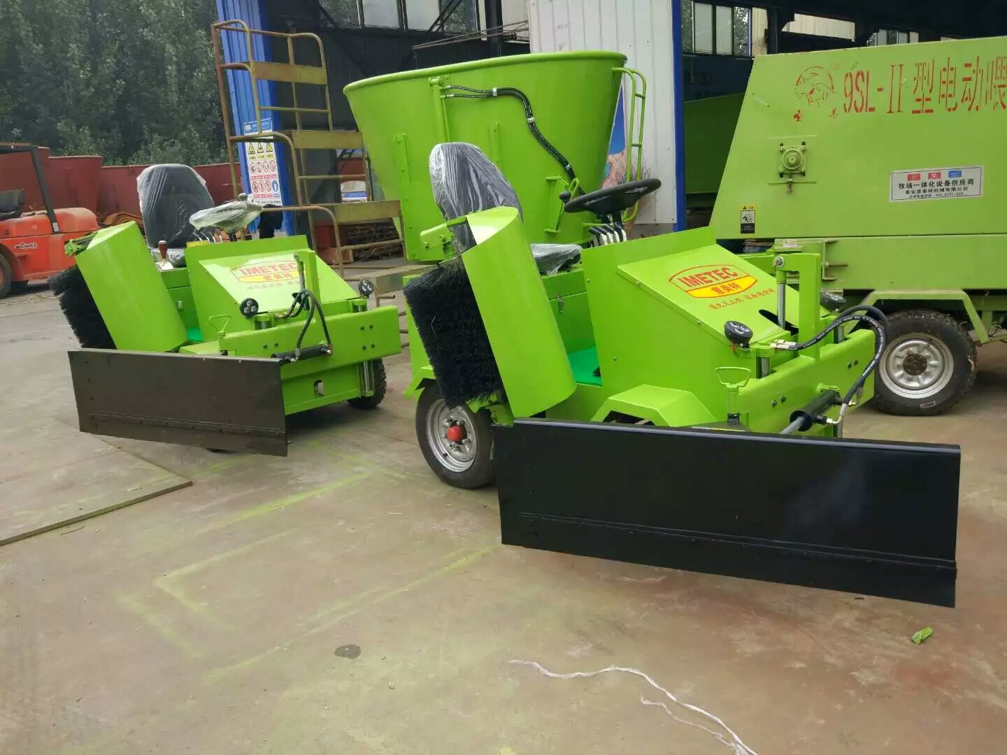 Electric feed pusher showing front blade and side brushes