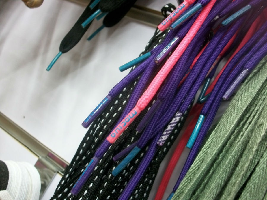 Assortment of shoelaces with different colored tips produced by the machine