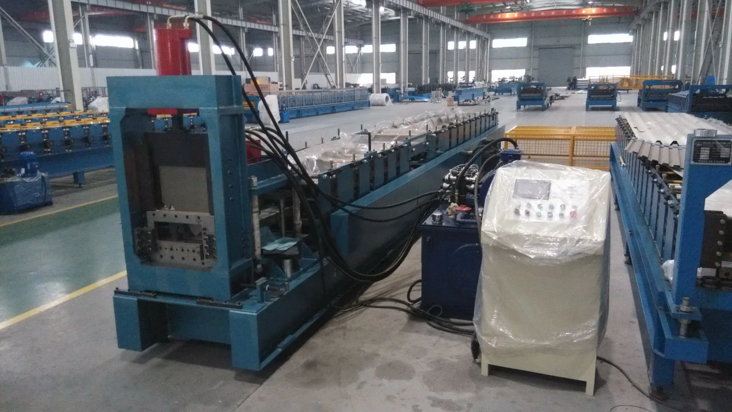 Detailed view of the roll forming machine steel frame and hydraulic cutter