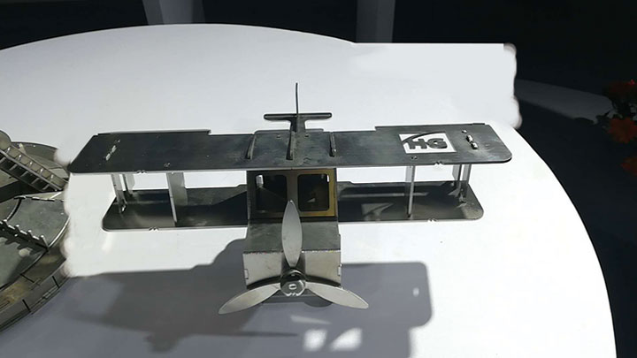 Intricate metal biplane model demonstrating laser cutting precision