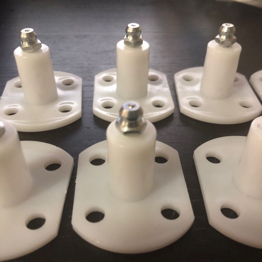 Adhesive surface injection packer showing white plastic base and metal nipple