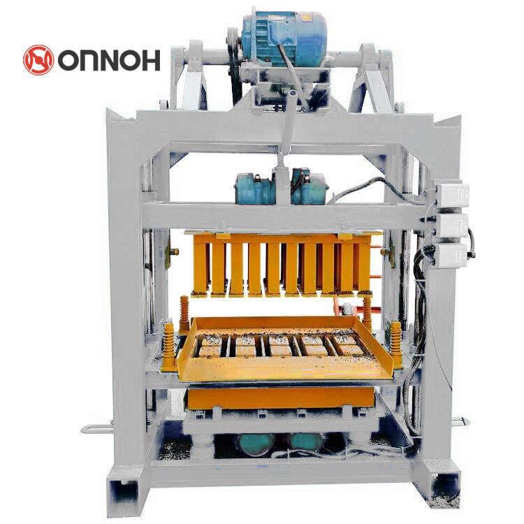 Manual concrete block machine in a workshop setting