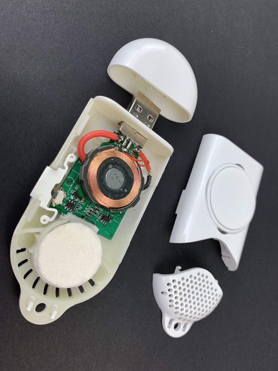 Disassembled aromatherapy device showing internal circuit board and coil