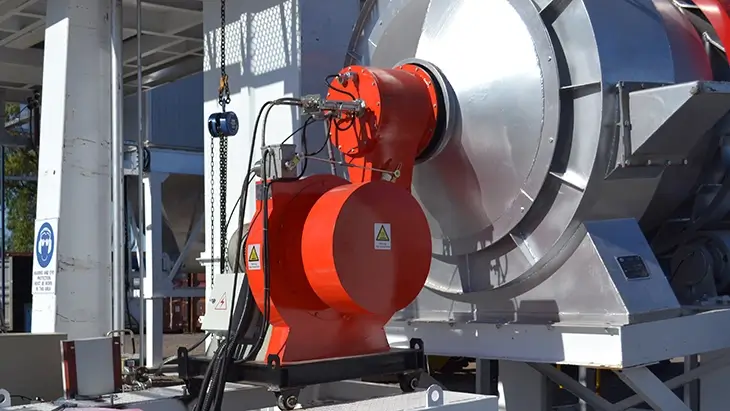 Industrial oil burner unit on a wheeled platform connected to machinery