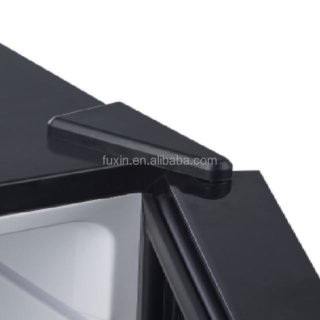Compact black hotel mini fridge showing interior lighting