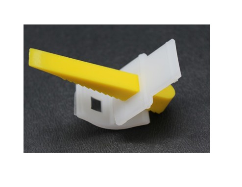 Plastic tile spacer with yellow wedge