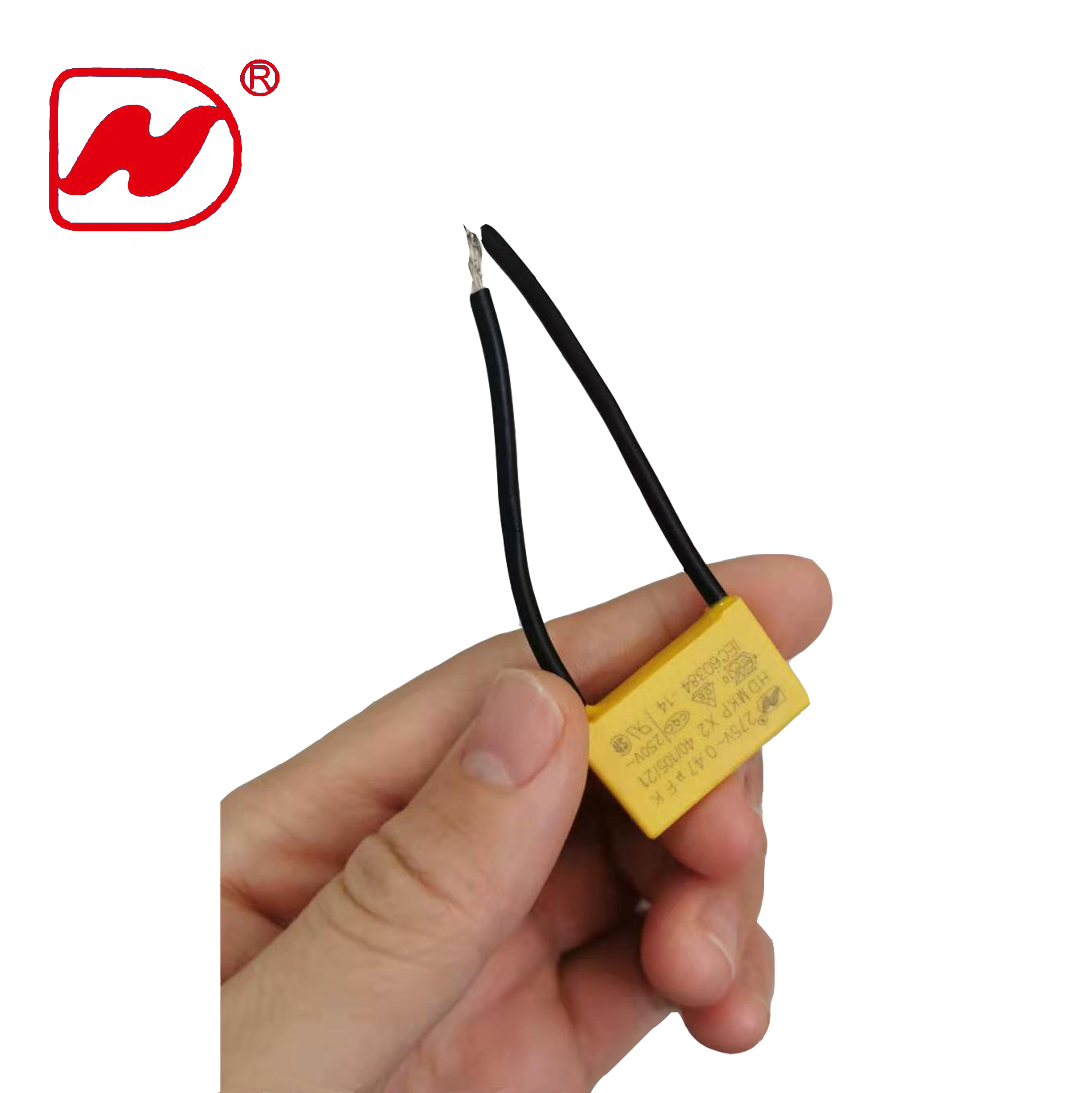 Close-up of yellow box-type X2 capacitor with leads